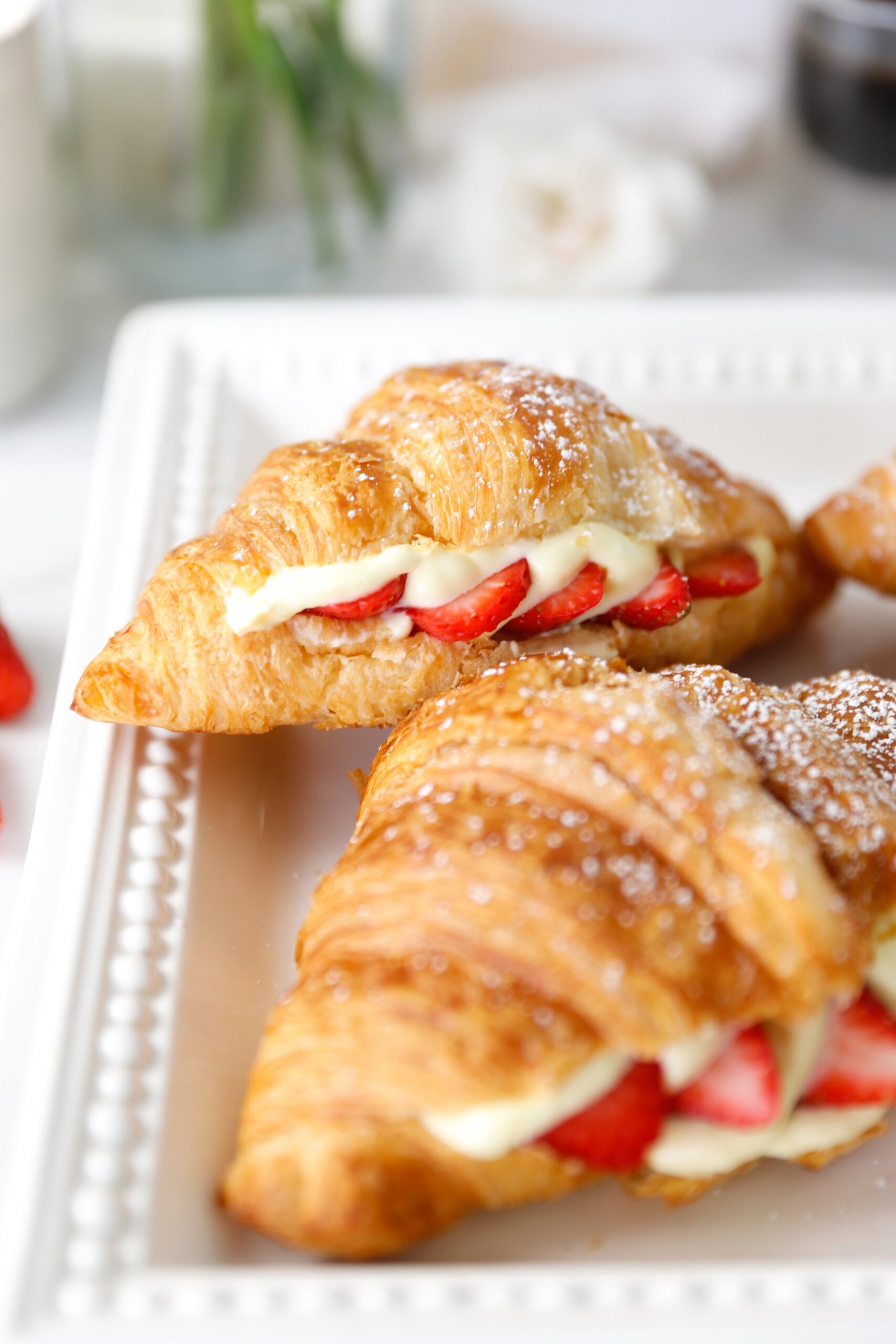 berry croissants dusted with powdered sugar served on a platter for brunch
