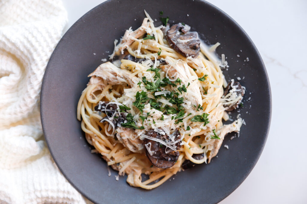 Creamy slow cooker chicken tetrazzini served on a black plate with parmesan and parsley