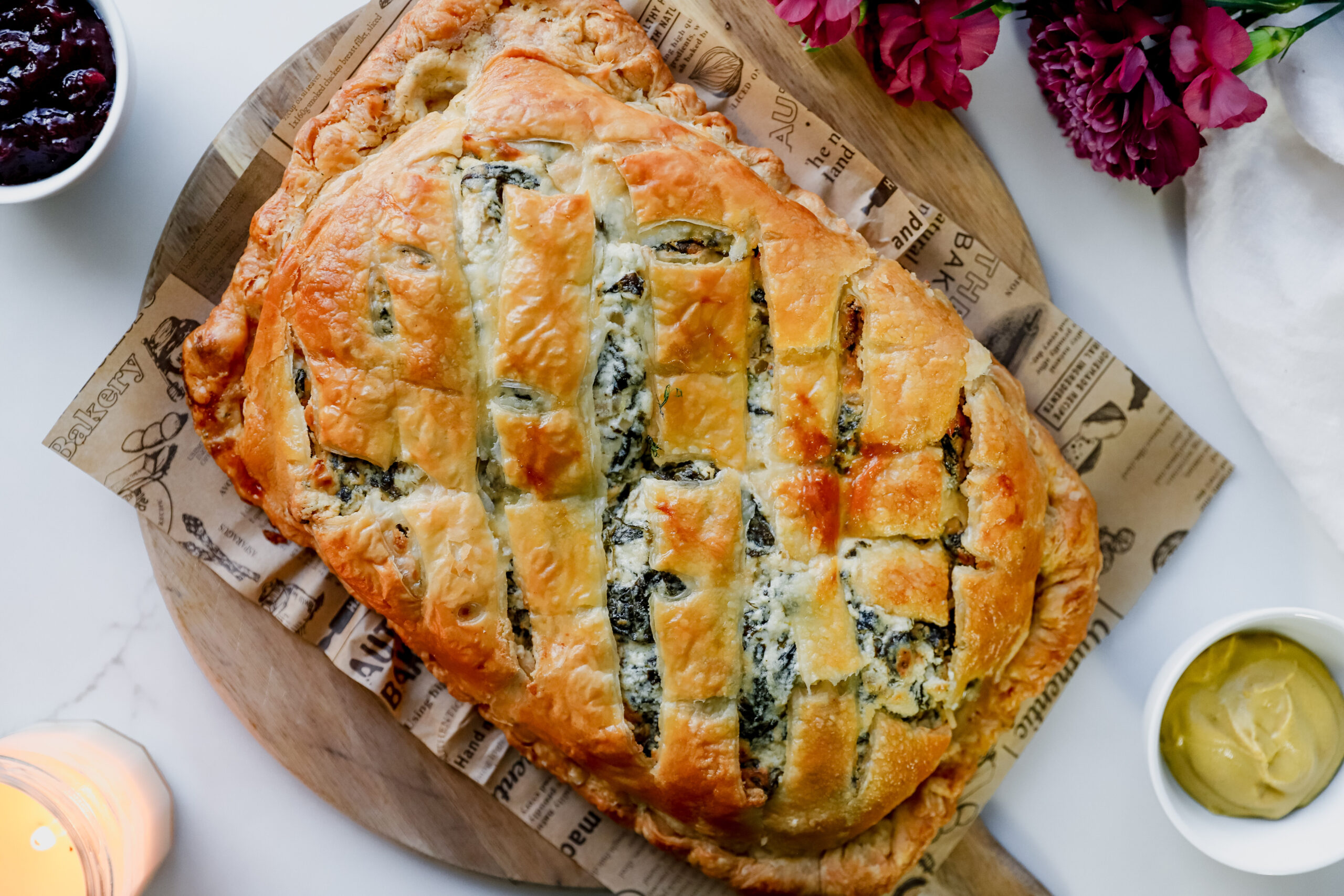 Overhead photo of baked Salmon en Croûte with dijon mustard and cranberry jam on the side.