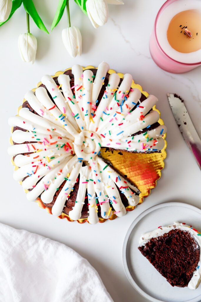 Chocolate chocolate chip bundt cake with a slice removed showing moist crumb and chocolate chips.