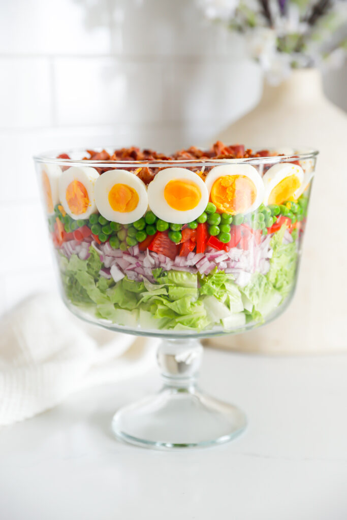Layered salad in glass bowl.